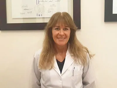 Retrato de la Dra. Graciela Cividino con ambo blanco en su consultorio